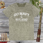 Green t-shirt with 'Go Navy, Beat Army, It's Tradition' text on a wooden background with nautical items.