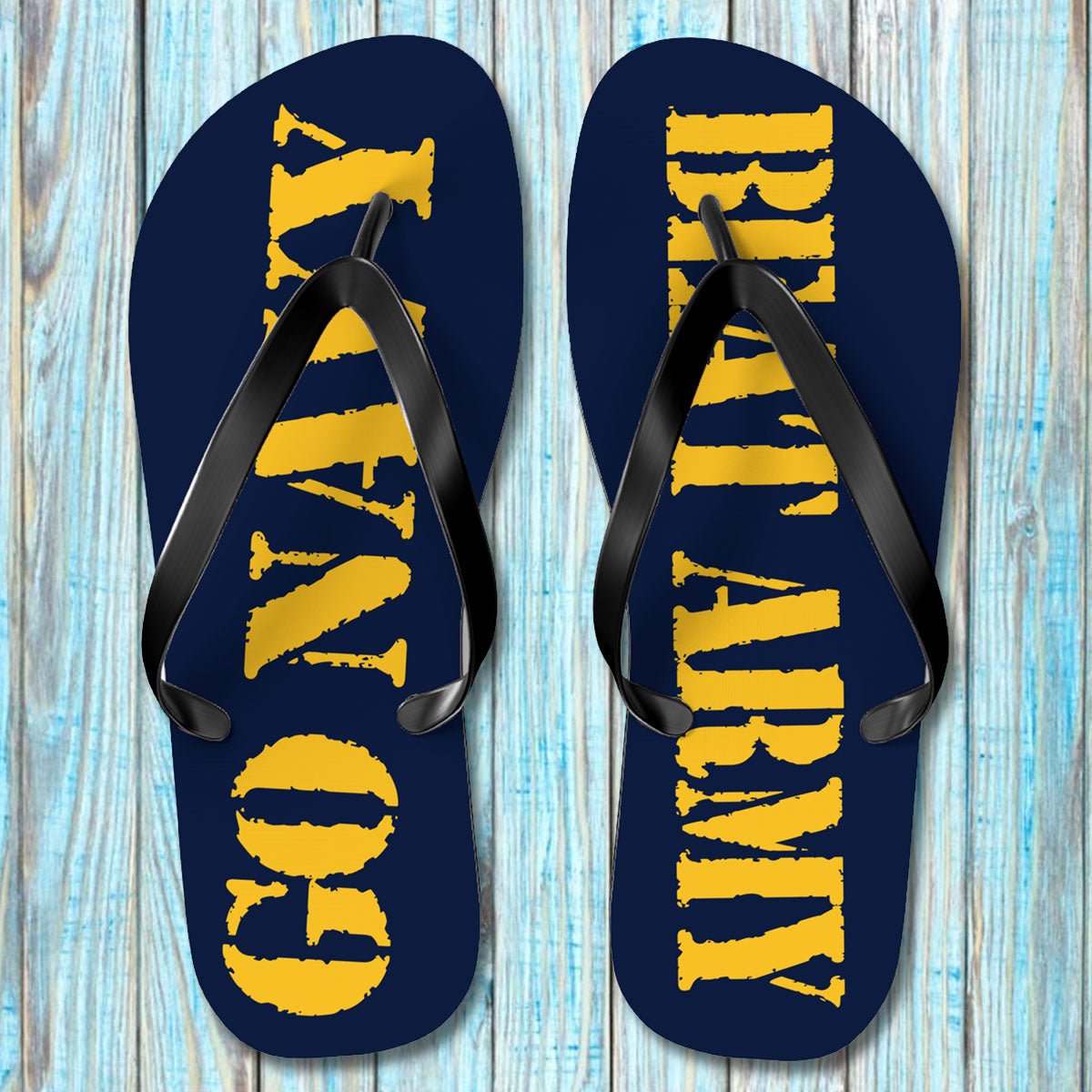 Pair of navy blue flip-flops with yellow text on a wooden surface
