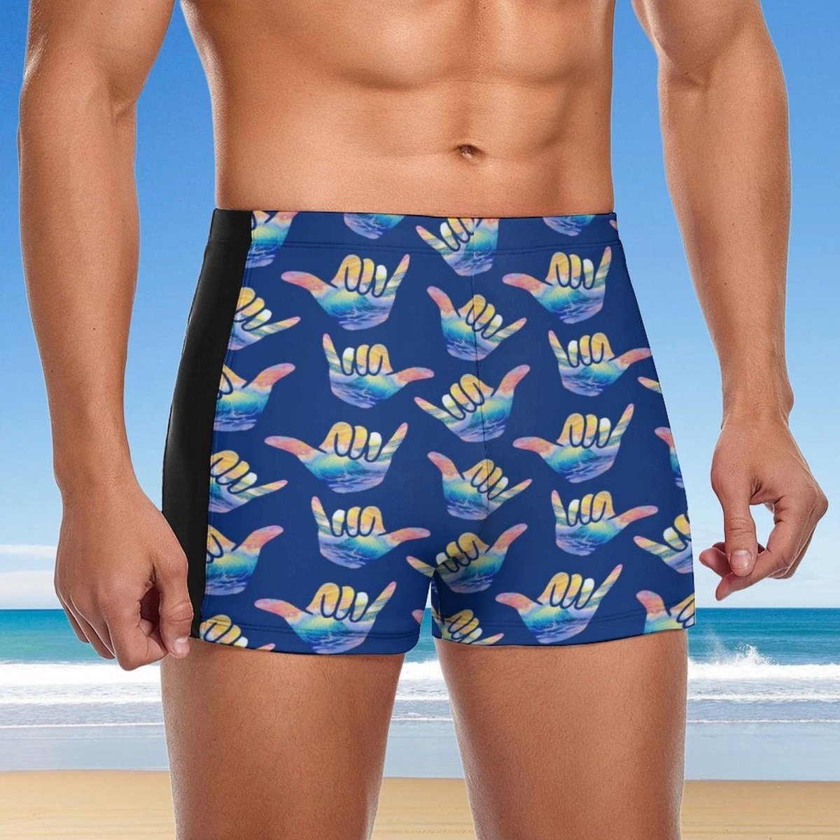 Person wearing blue swim shorts with colorful shaka hand signs on a beach background
