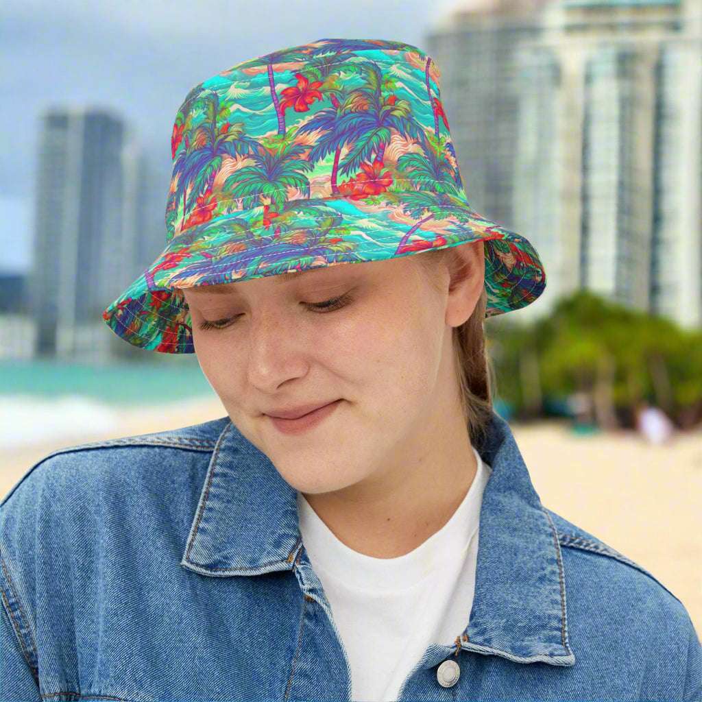 Girl wearing a bucket hat with a Hawaiian style patten standing on the beach in Waikiki