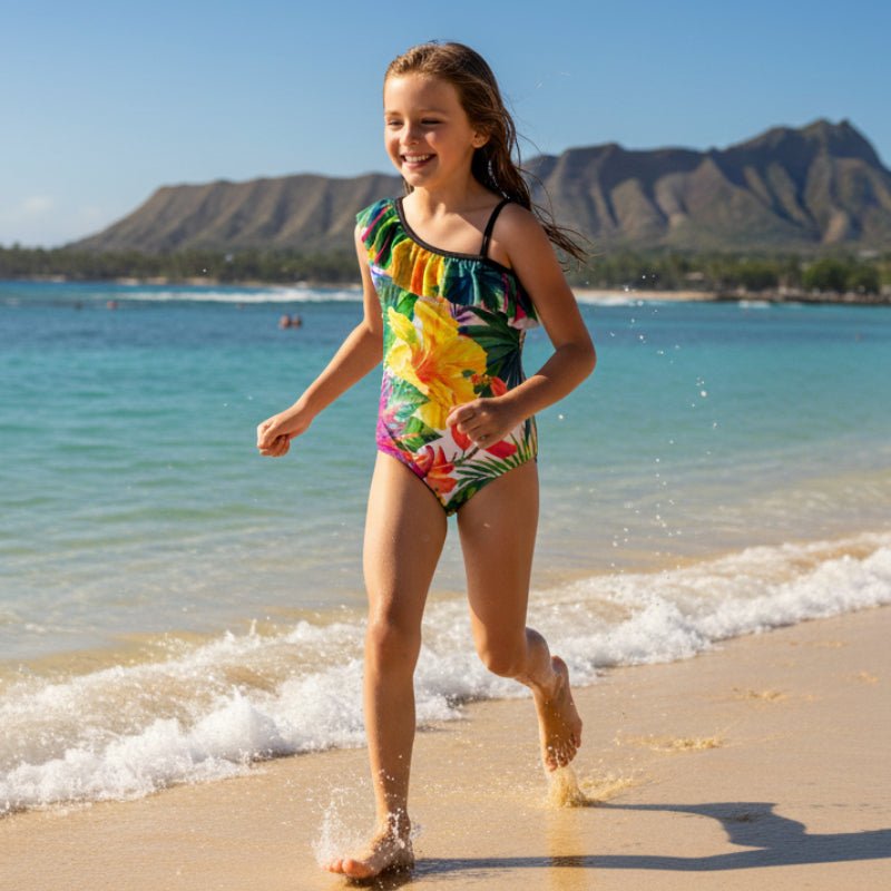 Girl wearing a Colorful tropical floral swimsuit running and playing on Waikiki Beach with Diamond Head Mountain in the background