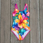 colorful floral swimsuit on a rustic nautical wood background