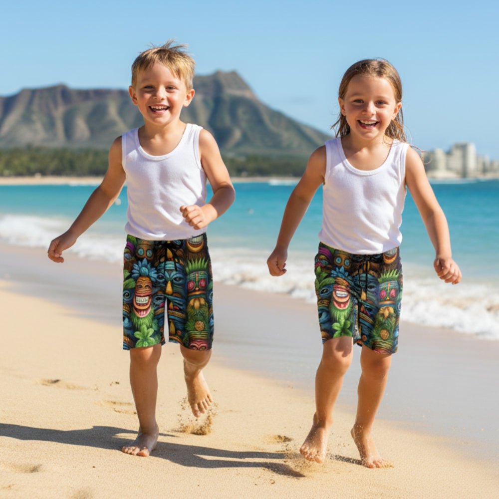 Two children running on Waikiki Beach wearing Kids Tiki Beach Shorts with Diamond Head mountain in the background