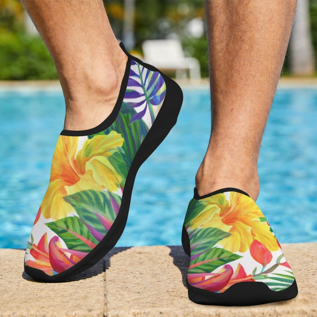 A person wearing slip-on Men's Beach Shoes with a tropical floral print, standing on a pool deck with a swimming pool in the background.