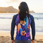 Surfer dude wearing a colorful rash guard with floral and surfboard design on Waikiki beach