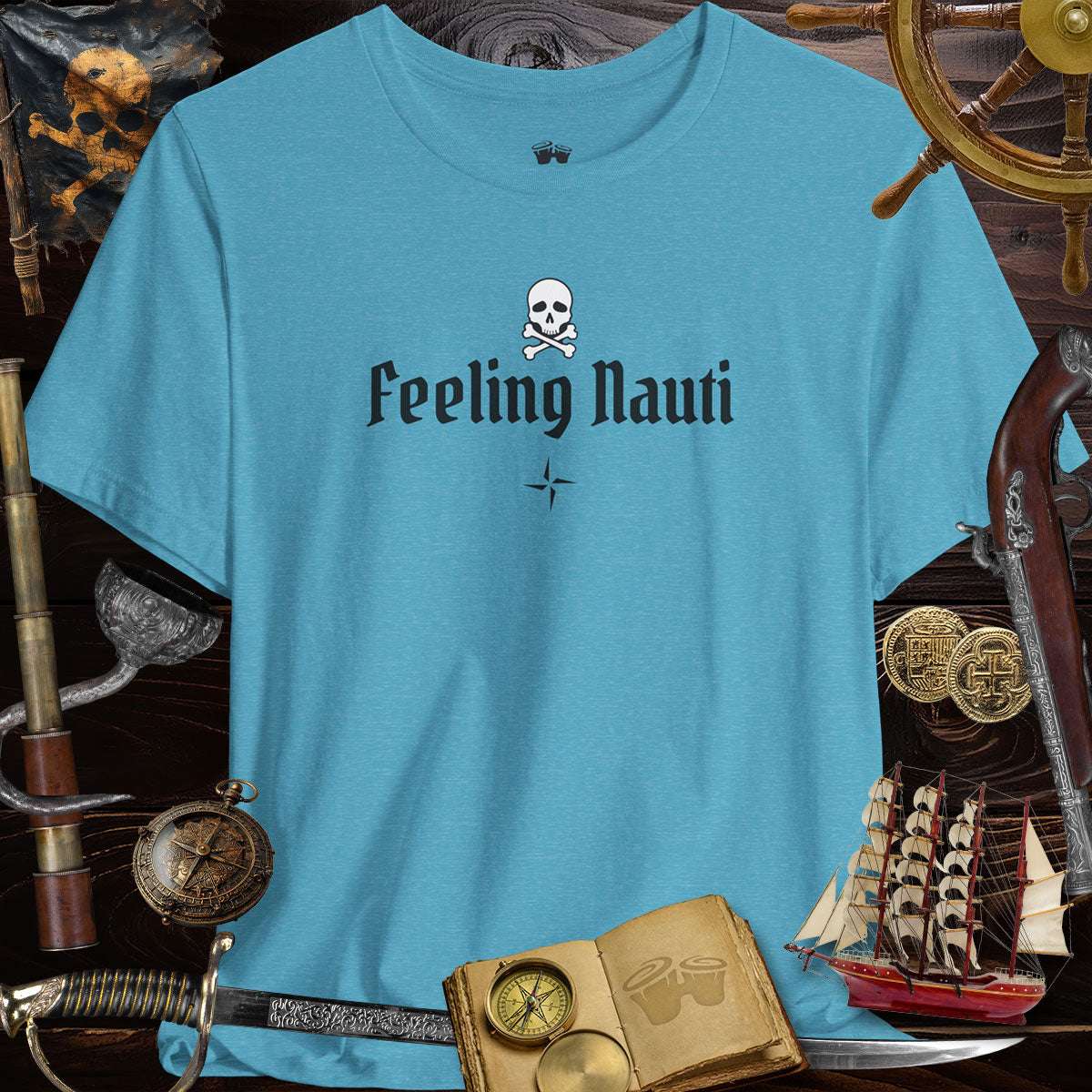 Feeling Nauti' Skull & Crossbone Unisex Pirate Tee on a blue shirt surrounded by pirate-themed decor.