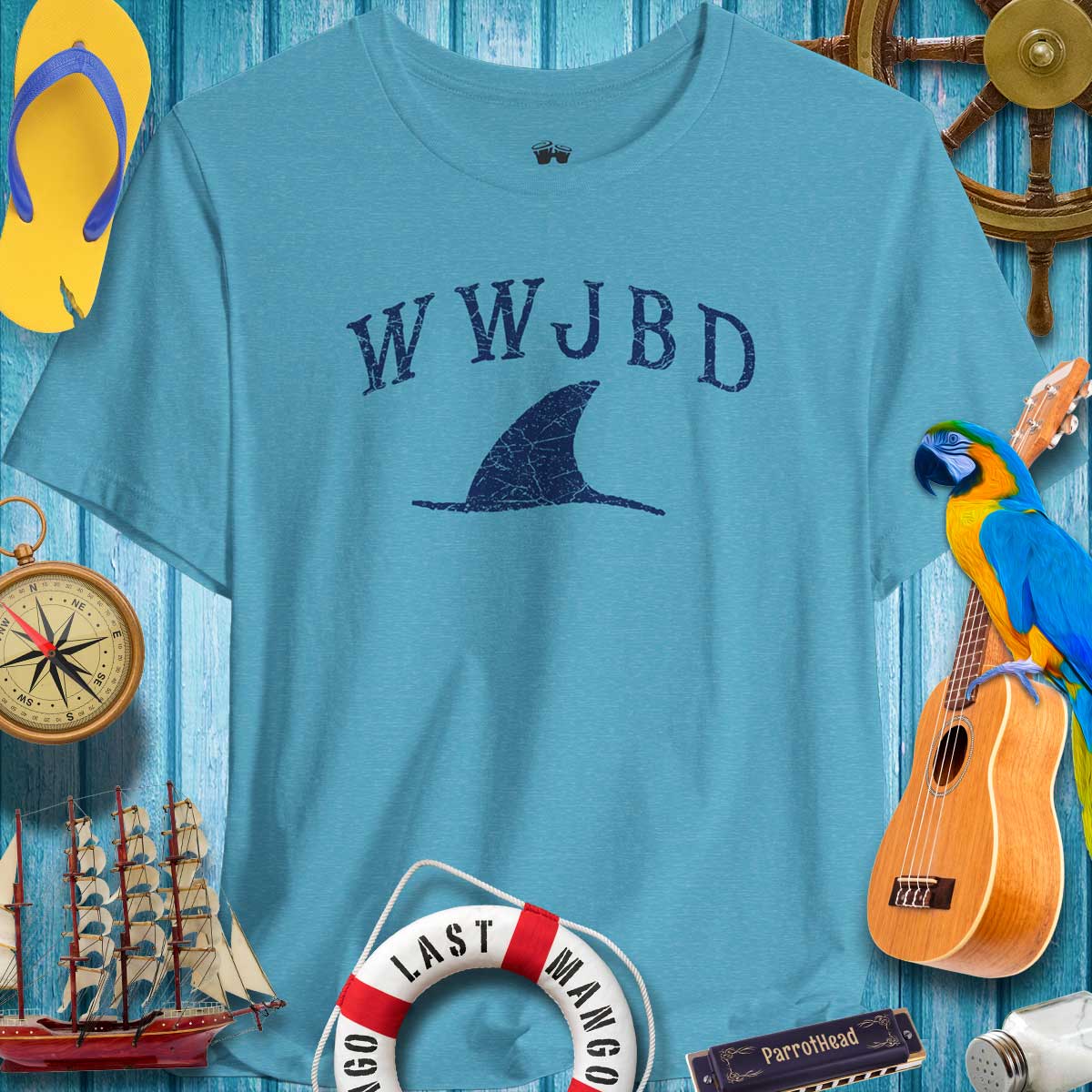 WWJBD Shark Fin Unisex Tee in blue, perfect for beach vibes and ParrotHeads, surrounded by nautical decor.