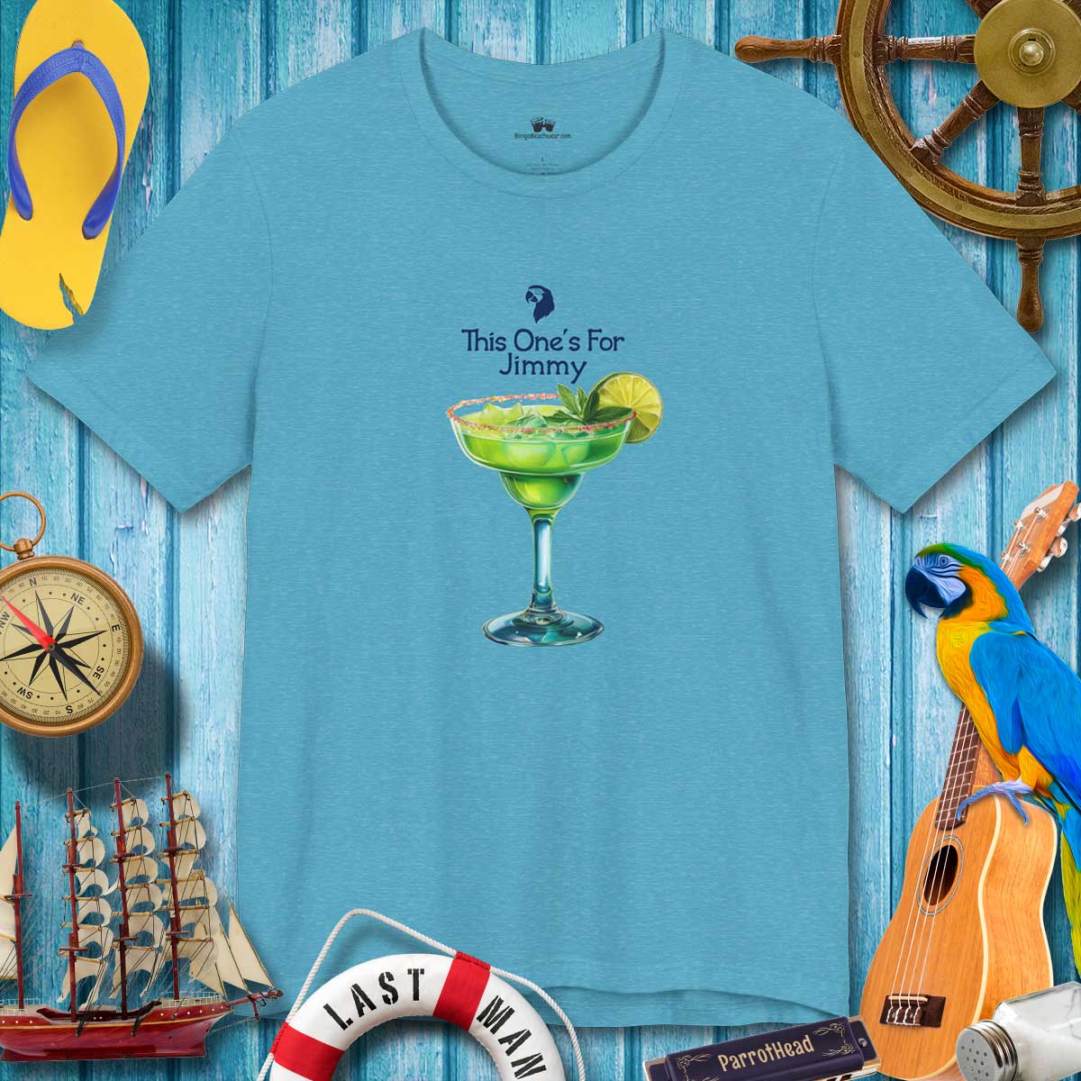 Blue t-shirt with a cocktail graphic and text on a wooden background with nautical items.