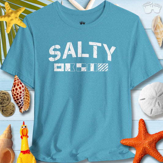 Salty Coastal Vibes Bella Canvas T-Shirt in blue, featuring nautical signal flags, surrounded by seashells and beach decor.