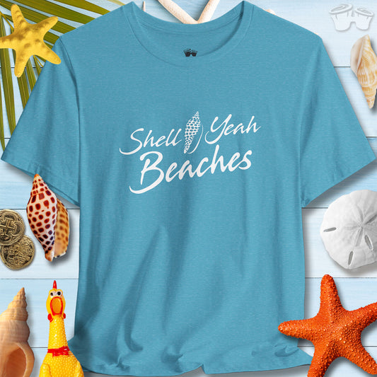Turquoise unisex tee with 'Shell Yeah Beaches' design, surrounded by seashells and beach-themed decor for summer vibes.