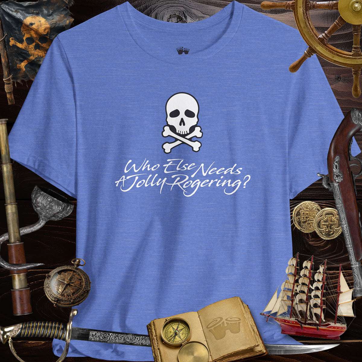 Funny Pirate Tee featuring a skull and crossbones with the text 'Who Else Needs A Jolly Rogering?' on a blue background.