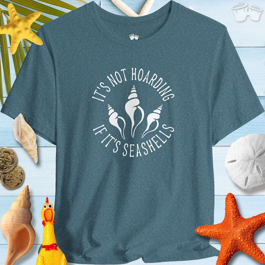 Beach Lover's Unisex Tee - 'It's Not Hoarding If It's Seashells' shirt surrounded by seashells and beach decor.