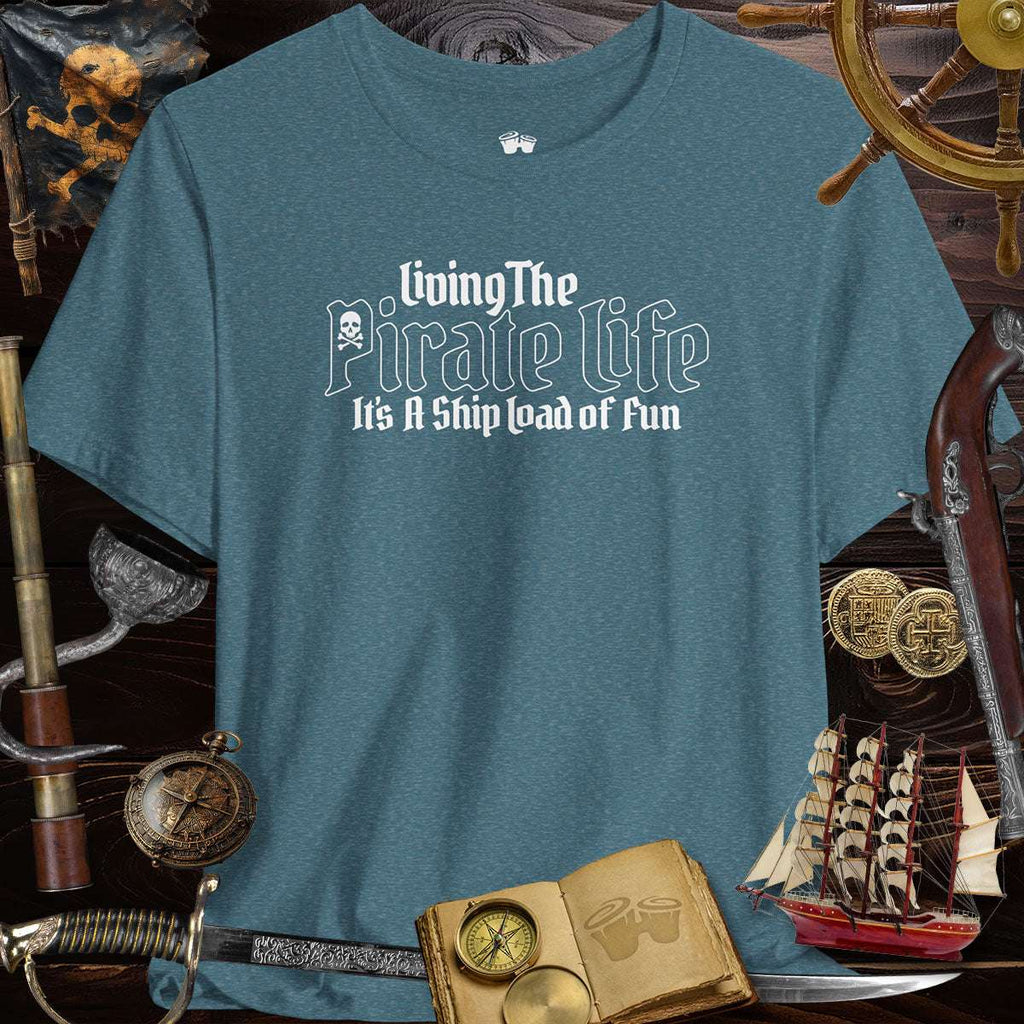 Pirate's Life unisex tee in teal, featuring playful design and surrounded by pirate-themed accessories.