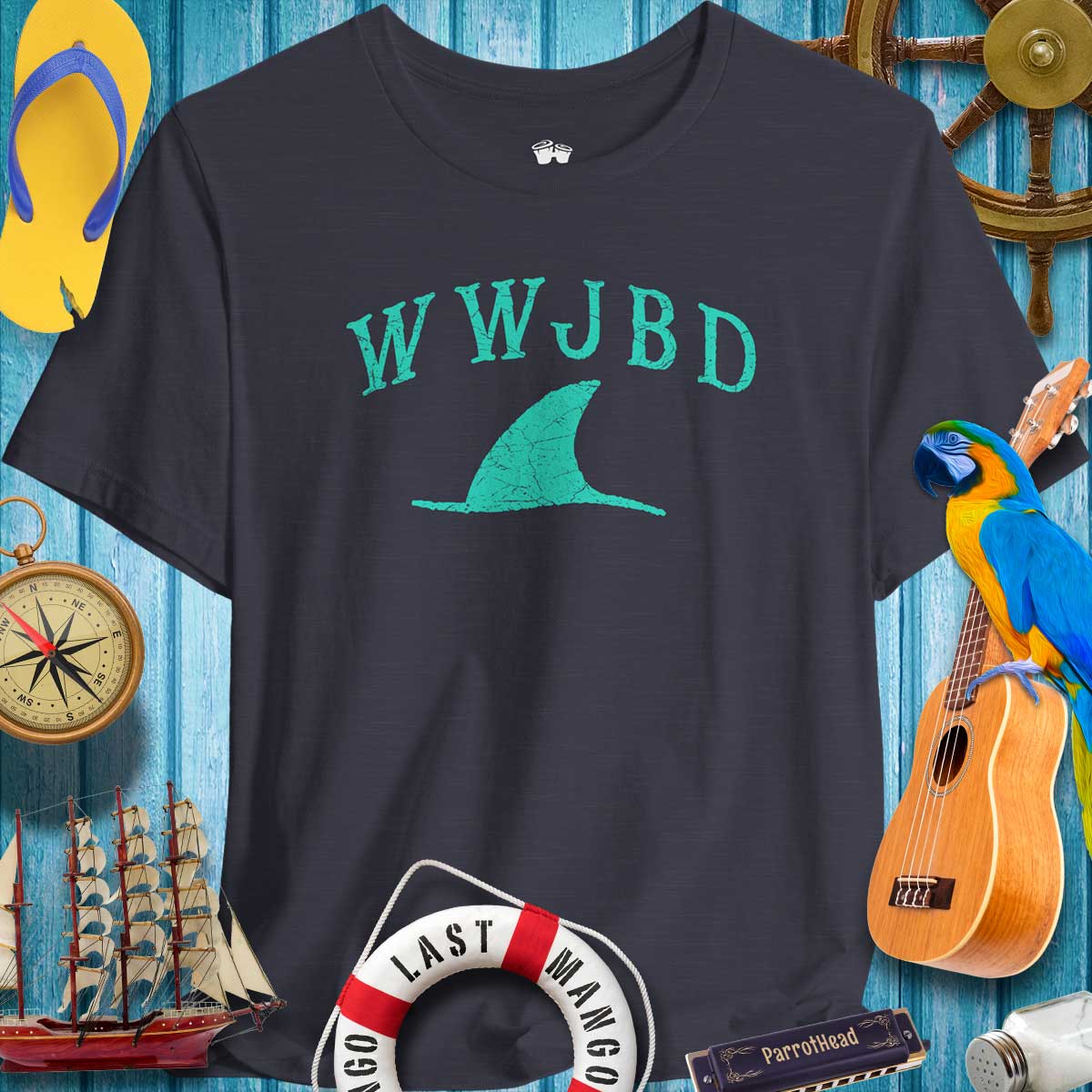 WWJBD Shark Fin Unisex Tee displayed against a beach-themed backdrop, perfect for ParrotHeads and casual summer vibes.