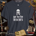 Yo Ho Ho Beaches Jolly Roger Pirate tee shirt on rustic background with nautical accessories and pirate imagery.