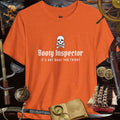 Booty Inspector Funny Pirate's Tee, orange shirt with skull and playful text, perfect for casual outings and humor lovers.