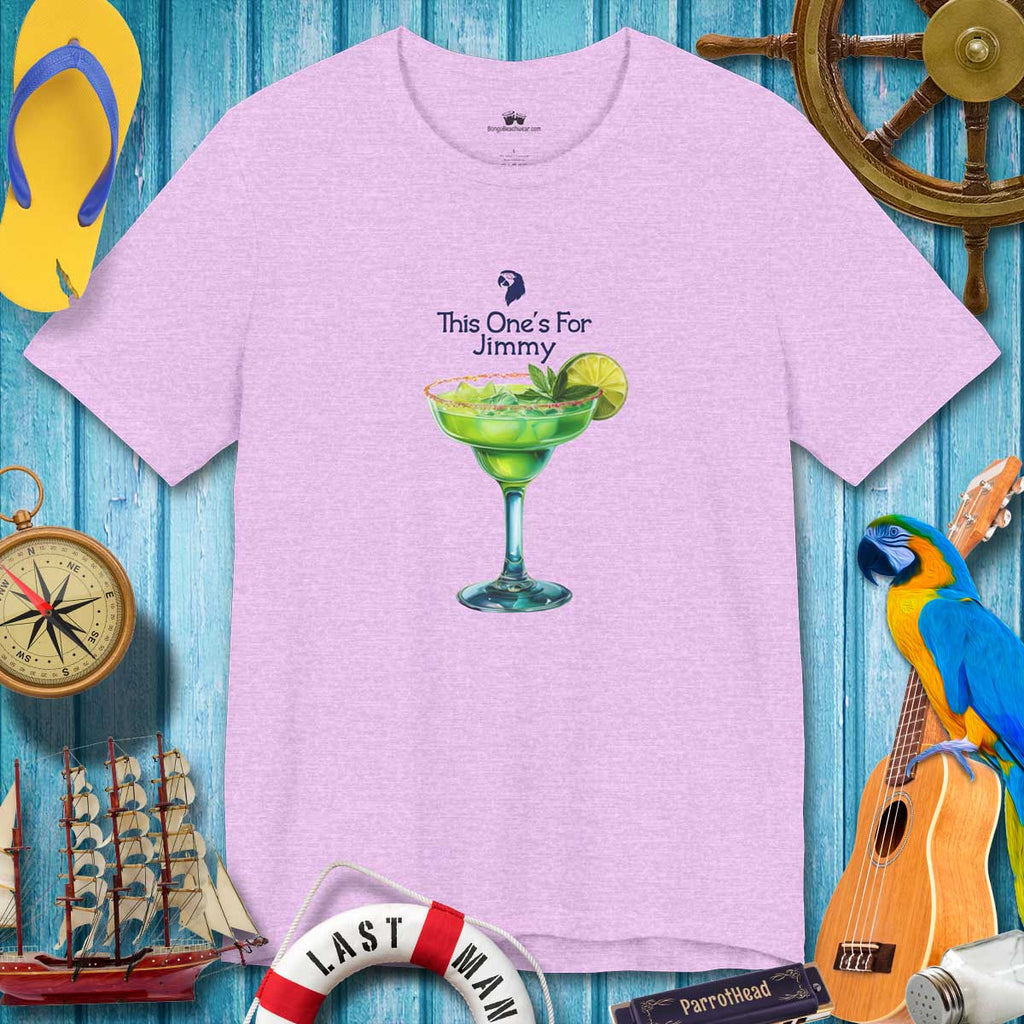 Purple t-shirt with a cocktail graphic and text on a blue wooden background with tropical items.