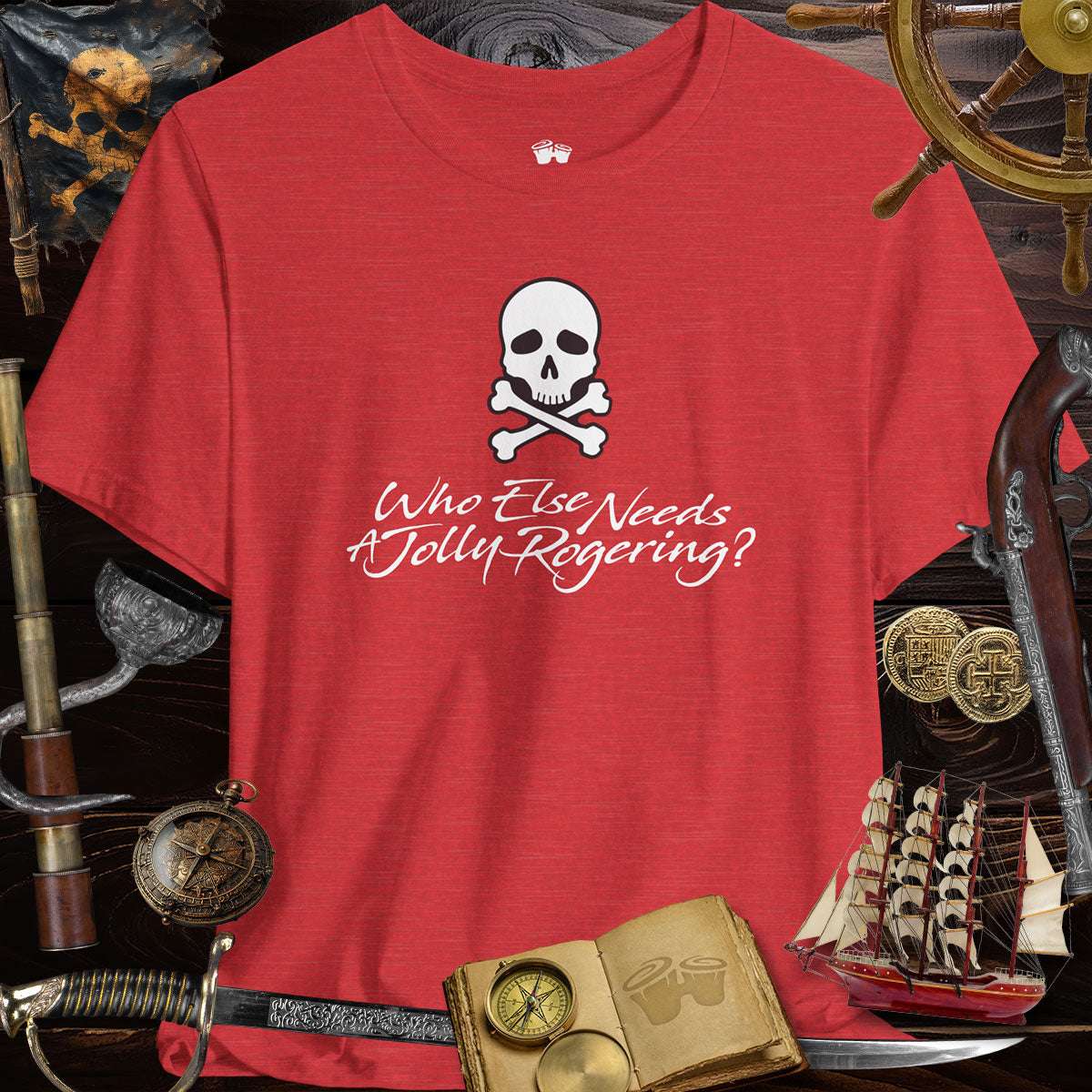 Funny Pirate Tee featuring a skull and crossbones with the text 'Who Else Needs A Jolly Rogering?' on a red shirt.
