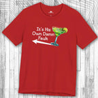 Red t-shirt with a graphic of a cocktail and text: "It's His Own Damn Fault" on a wooden surface.