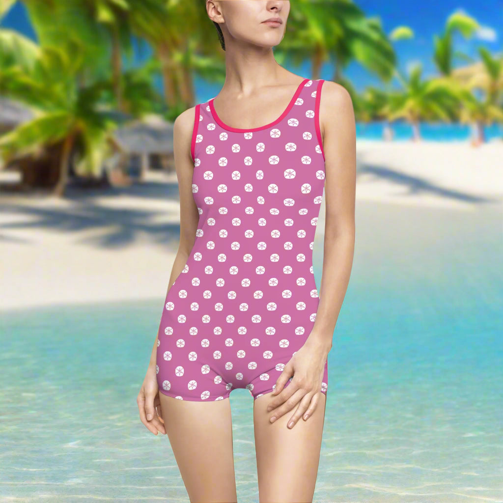 model in hot pink vintage bathing suit with white sand dollar polka dots looking for seashells in an island paradise