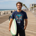 Surfer dude on the Atlantic Boardwalk wearing a navy blue short-sleeve crewneck t-shirt featuring a colorful sea life sugar skull graphic.