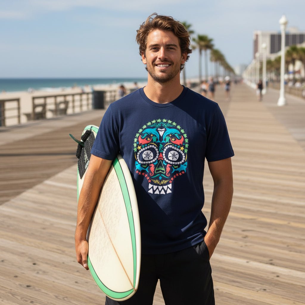 Surfer dude on the Atlantic Boardwalk wearing a navy blue short-sleeve crewneck t-shirt featuring a colorful sea life sugar skull graphic.