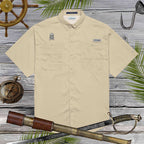 Beige shirt with Jolly Roger Pirate skull embroidery on a wooden background with ship wheel, compass, and sword.