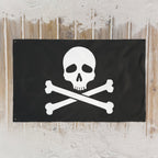 Jolly Roger pirate flag laying flat on a sandy boardwalk