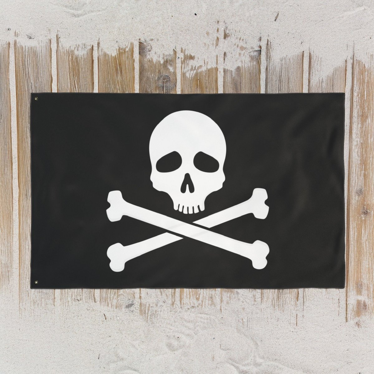 Jolly Roger pirate flag laying flat on a sandy boardwalk