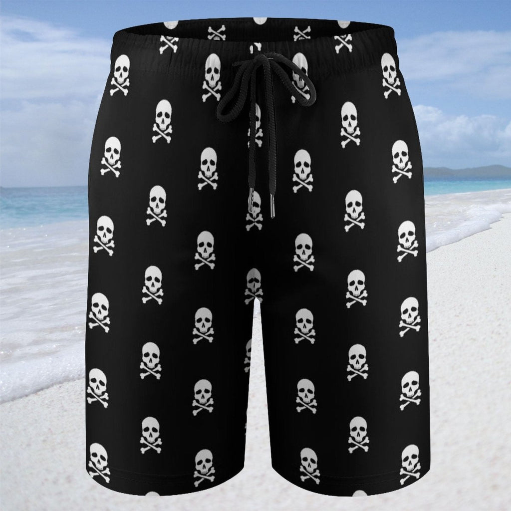 Black shorts with white skull and crossbones pattern on a beach.