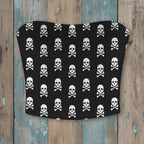 Black strapless top with white skull and crossbones pattern on a rustic nautical wood background