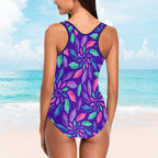 Woman wearing a purple floral swimsuit with a beach background