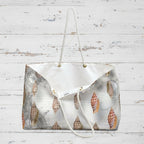 Patterned handbag with a white strap on a wooden surface