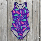 Colorful seashell-patterned swimsuit on a rustic wood background