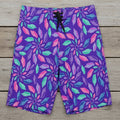 Purple board shorts with colorful junonia seashell pattern on a rustic wood background