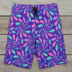 Purple board shorts with colorful junonia seashell pattern on a rustic wood background