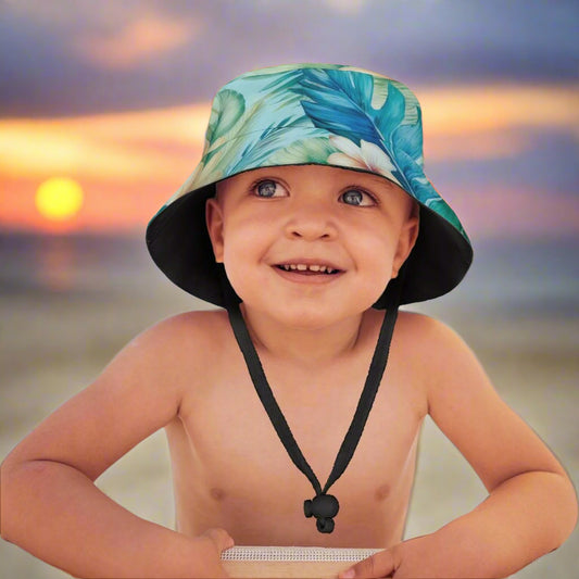 Child wearing a tropical leaf patterned sun hat with a beach background