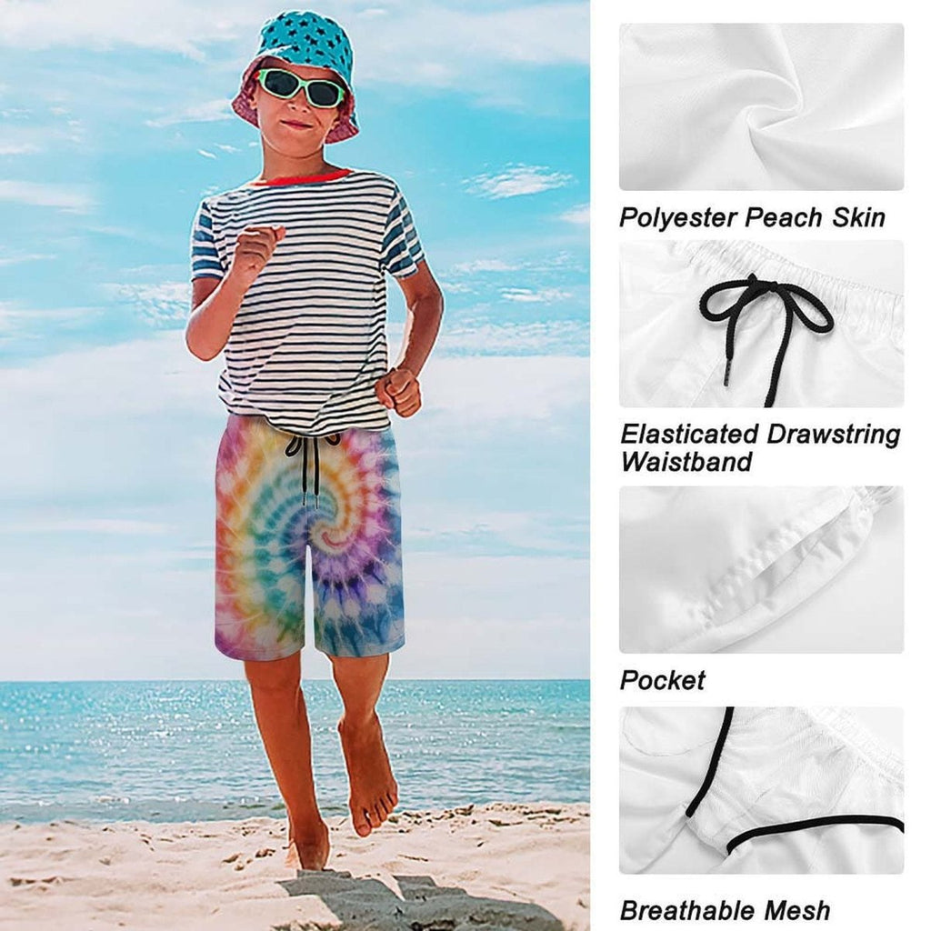 Child wearing a striped shirt, colorful tie-dye shorts, and a bucket hat on a beach with fabric details shown.