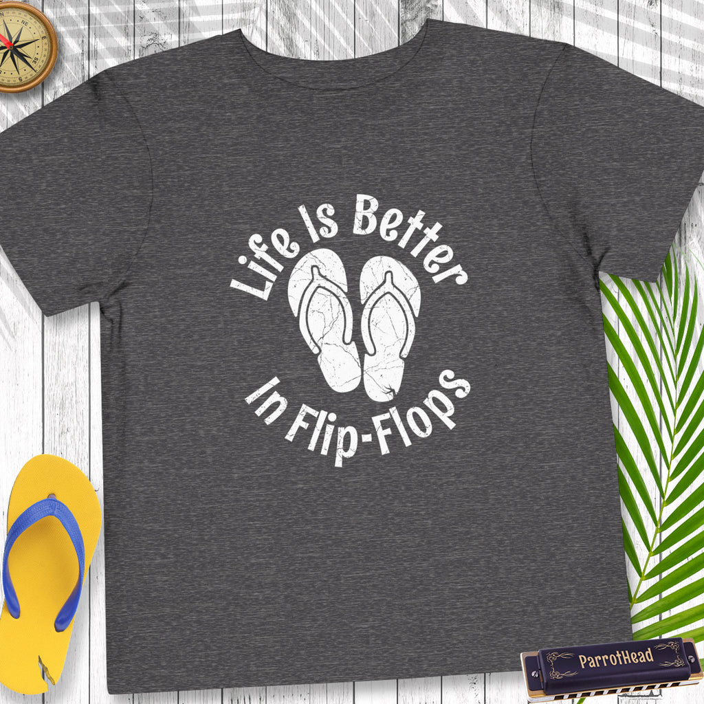 Gray t-shirt with 'Life is Better in Flip-Flops' text and flip-flop graphics on a wooden surface.