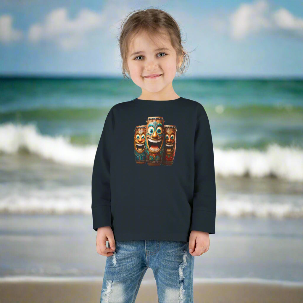 Little girl wearing a black long sleeve t-shirt with laughing tiki bongos design having fun on Cocoa Beach