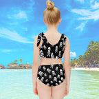 Girl wearing a black and white skull-patterned swimsuit on at a tropical island resort