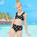 Girl wearing a Black Pirate Swimsuit set with skull and crossbones pattern pirate on a tropical island beach