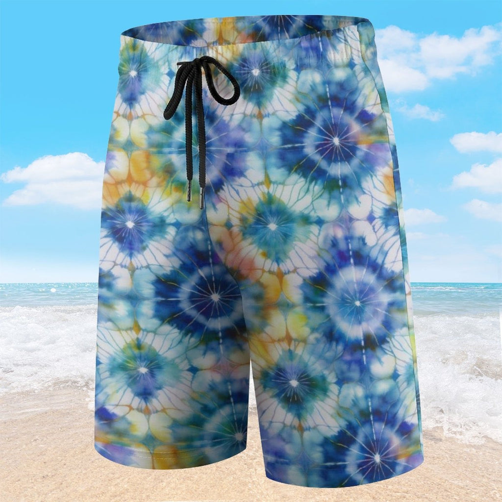 Colorful tie-dye shorts on a beach with ocean and sky background