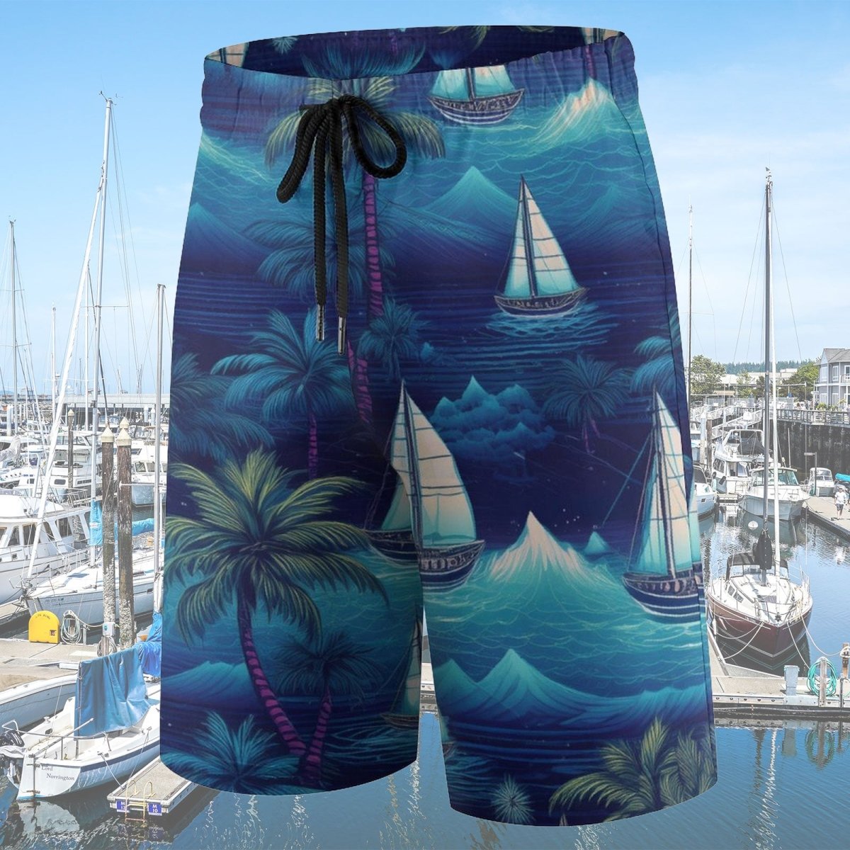 Beach shorts with a sailboat and palm tree pattern displayed in front of a marina.