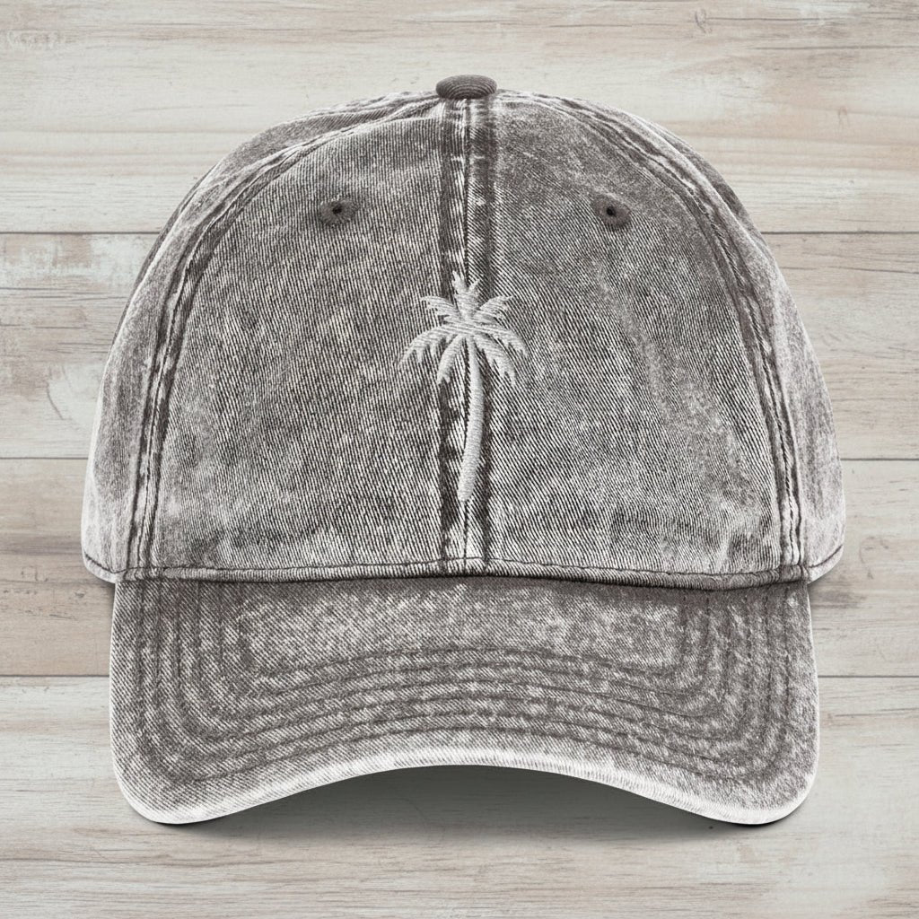 Gray denim cap with embroidered palm tree on a rustic wood background