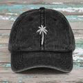 Black denim cap with embroidered king palm tree on rustic nautical wood