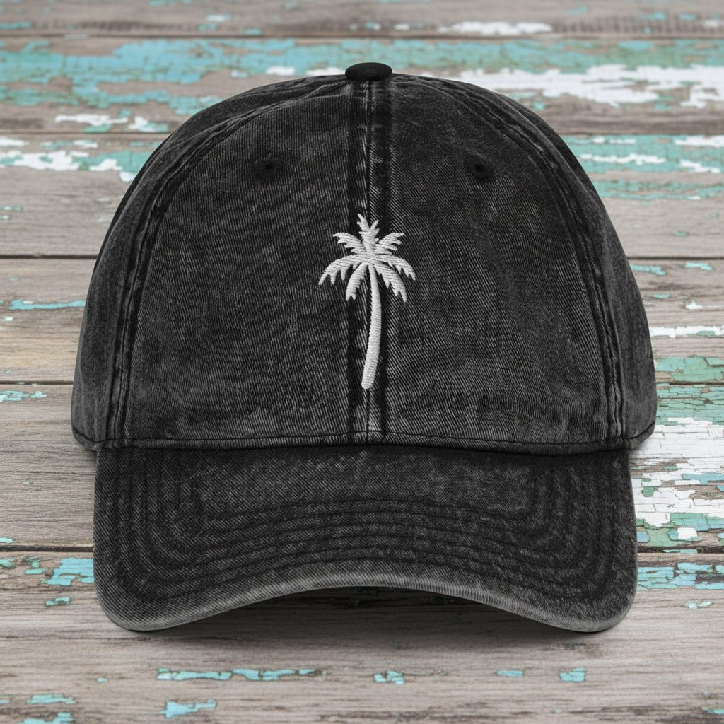 Black denim cap with embroidered king palm tree on rustic nautical wood