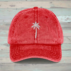 Red cap with white embroidered king palm tree on a rustic wood  background
