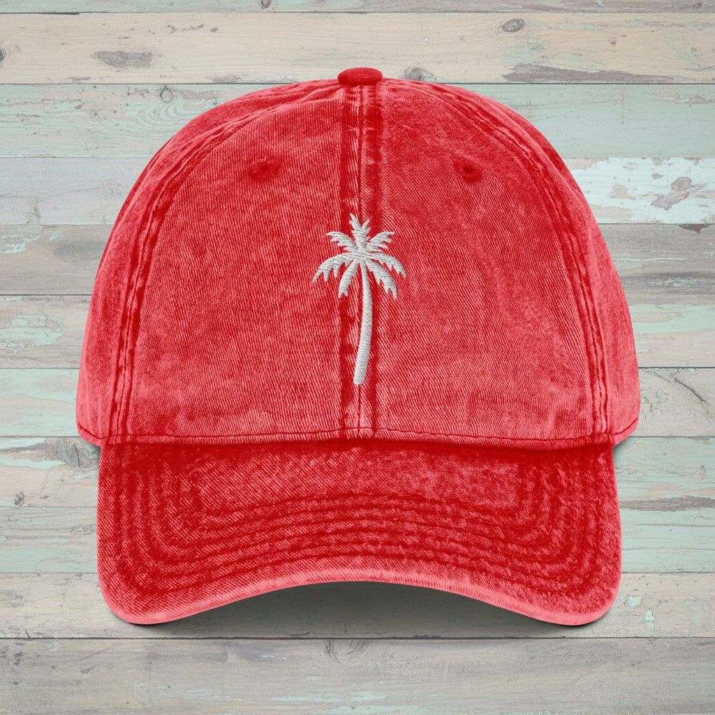 Red cap with white embroidered king palm tree on a rustic wood  background