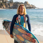Surfer dude wearing a long-sleeve shirt with colorful surfboard design on La Jolla Cove Beach